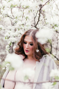 Beautiful girl in a dress walking in a blooming garden