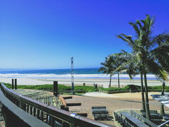 Scenic view of beach against clear blue sky