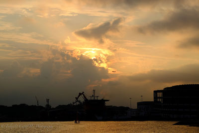 Scenic view of sea against cloudy sky at sunset