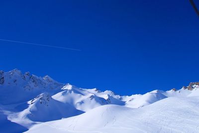 Scenic view of snowcapped mountains against clear blue sky