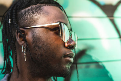 Close-up of young man with braided hair wearing sunglasses