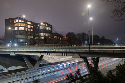 Illuminated bridge over canal in city at night