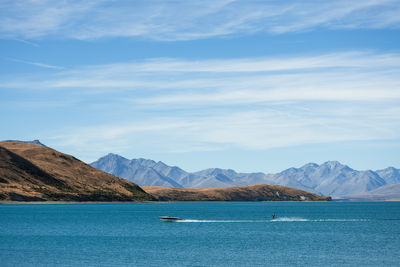 People boating in summer on lake tekapo, new zealand