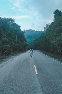 Rear view of man on road against sky