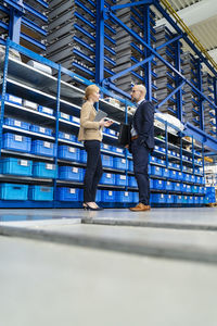 Businessman and businesswoman talking in factory