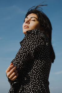 Low angle view of woman standing against sky