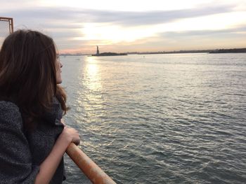 Woman traveling through staten island ferry in hudson river against sky