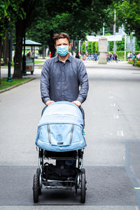 Portrait of young man on road in city