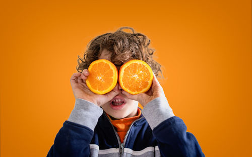 Portrait of man holding orange fruit