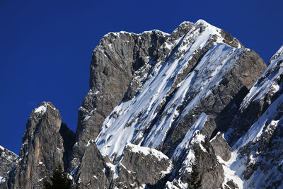 Low angle view of rocky mountains against clear sky