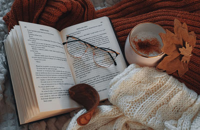 Christmas decorations with lights, hot drink, fruits and a good book