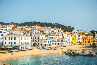 View of houses by beach against clear sky