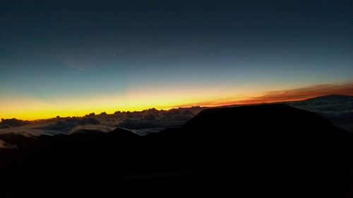 Scenic view of silhouette mountains against clear sky