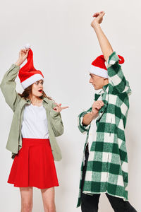 Couple gesturing against gray background