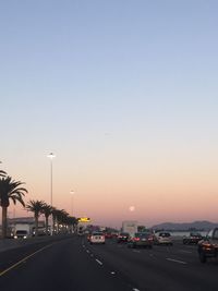 Cars moving on road at sunset