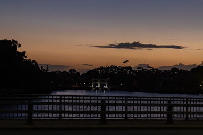 Silhouette trees and buildings against sky during sunset