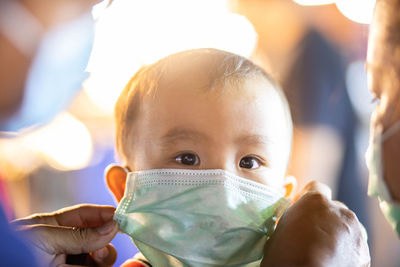 Close-up portrait of cute baby holding camera