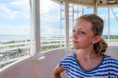 Portrait of woman looking away against window