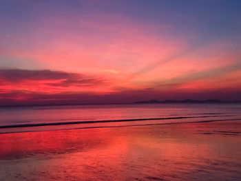 Scenic view of sea against dramatic sky during sunset