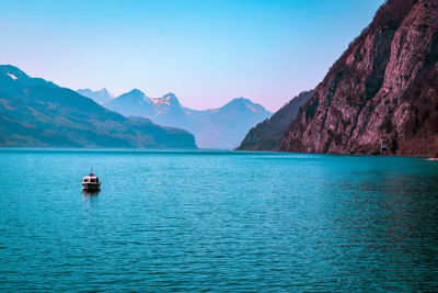 Scenic view of sea and mountains against clear sky