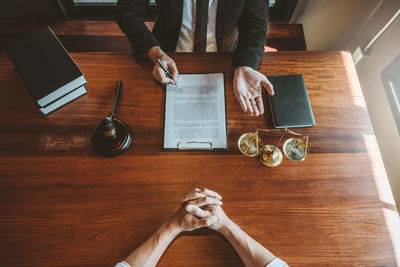 High angle view of man reading book on table
