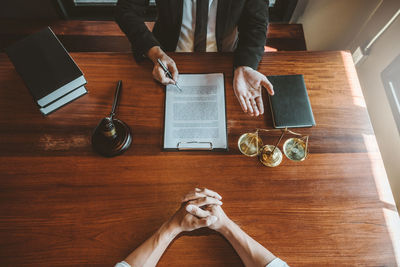 Midsection of men discussing on table