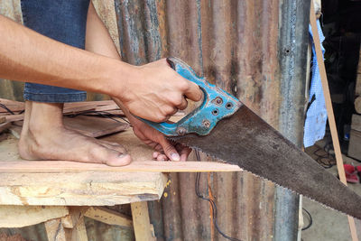 Cropped hand of man working on wood