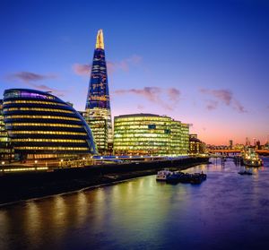 High angle view of thames river by illuminated modern buildings in city