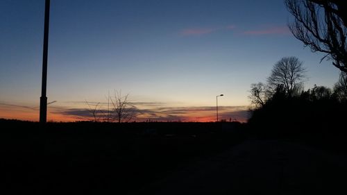 Silhouette trees against sky at dusk