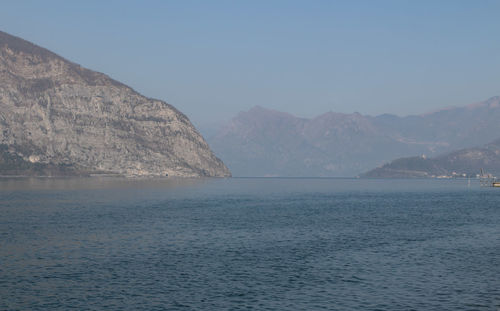 Scenic view of sea and mountains against clear sky