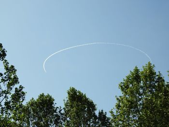 Low angle view of vapor trail against clear blue sky