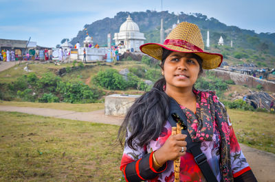 Woman looking away while standing on field