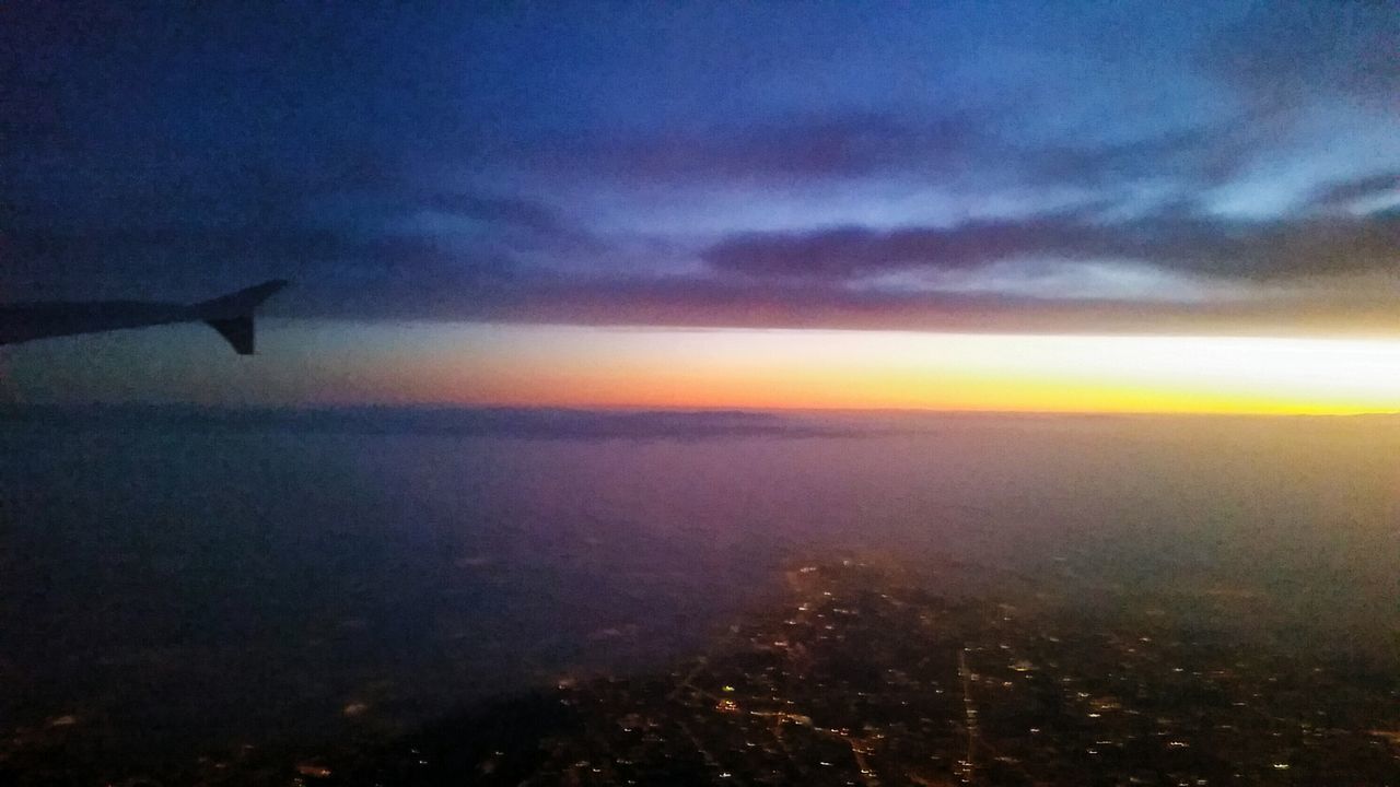 AIRPLANE WING AGAINST SKY AT DUSK