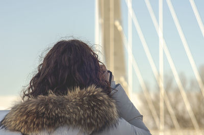 Rear view of woman against sky during winter