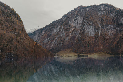 Scenic view of lake by mountains against sky