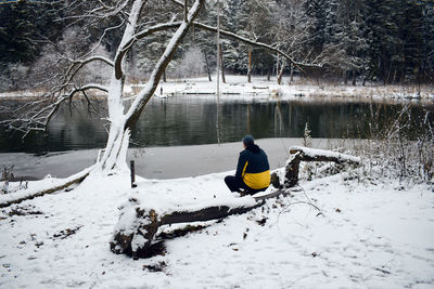 Man on snow covered tree during winter