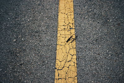High angle view of yellow arrow symbol on road