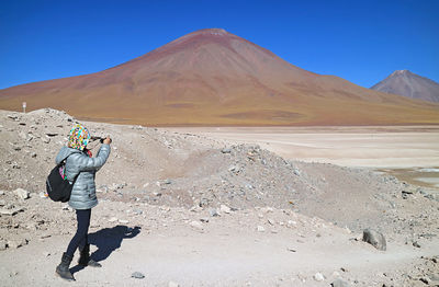 Traveler shooting photos of the landscape in eduardo avaroa andean fauna national reserve, bolivia