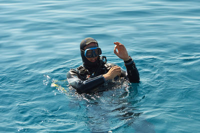 Man gesturing while snorkeling in sea