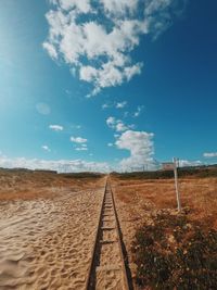 Railroad tracks on field against sky