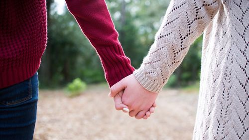 Low section of couple holding hands