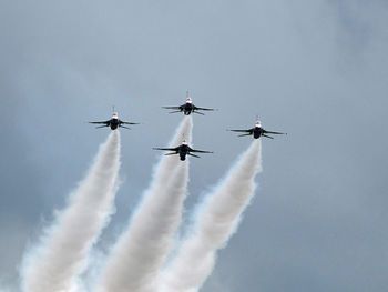 Low angle view of airshow against sky