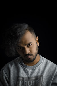 Portrait of man against black background
