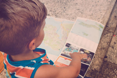 High angle view of boy looking at world map