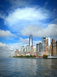 Buildings by sea against sky