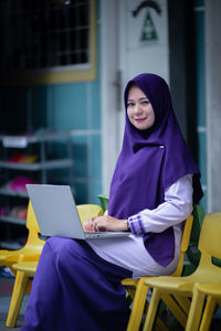 Young woman using laptop at cafe