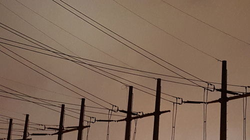 Low angle view of electricity pylon against sky