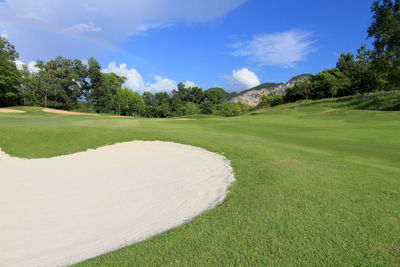 Scenic view of golf course against sky