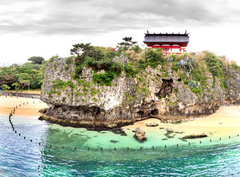 Built structure by sea against sky