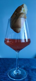 Close-up of beer glass on table against blue background